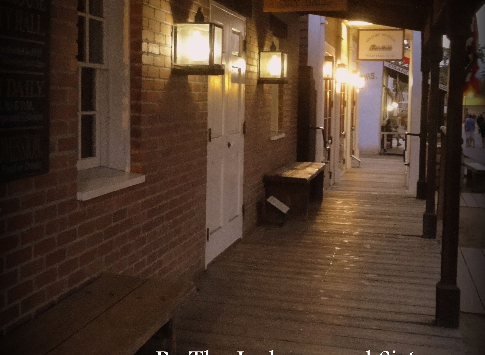 Lanterns glowing along the covered wooden boardwalk of Old Town San Diego at night